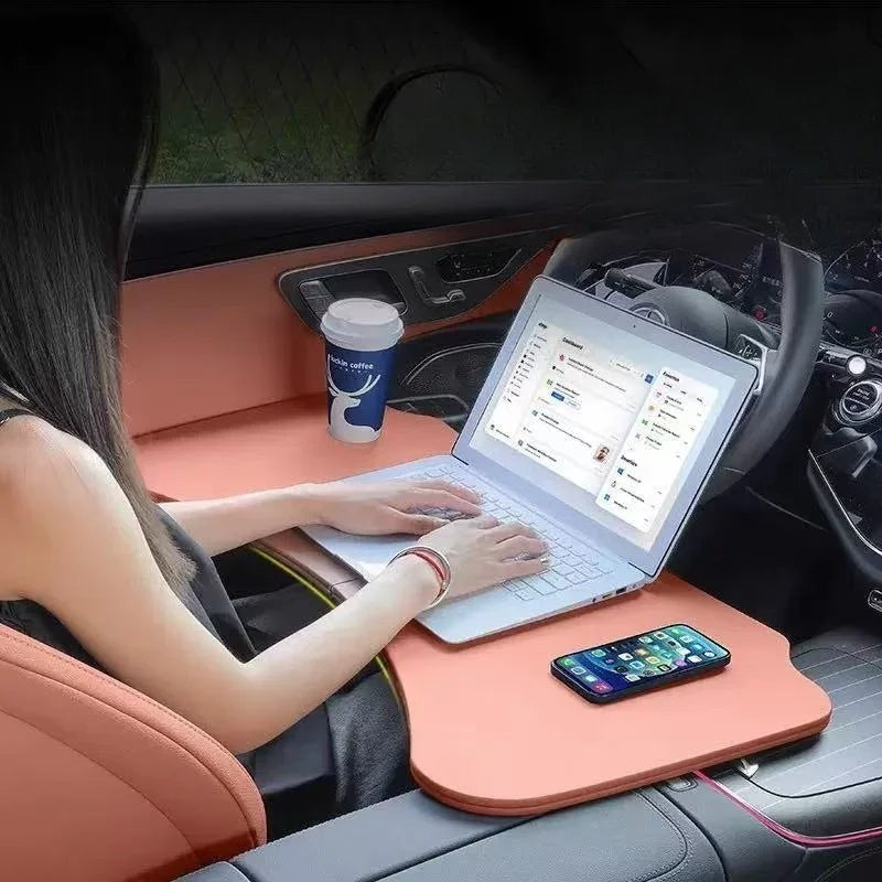 Sea Dragon Dreams folding car steering wheel table in peach, used as a portable laptop desk inside a parked vehicle.