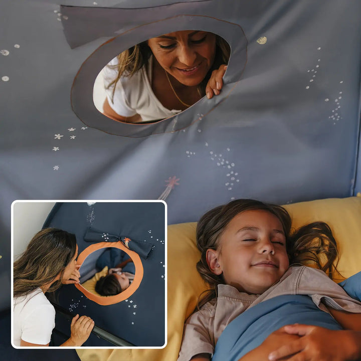 Sea Dragon Dreams galaxy-themed kids bed tent with a circular window, showing a mother peeking in at her sleeping child