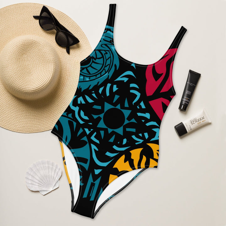 Sea Dragon Dreams one-piece swimsuit featuring a vibrant geometric tribal pattern in blue, red, and yellow.