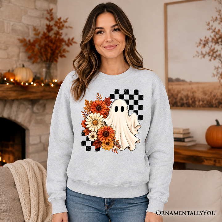 Sea Dragon Dreams grey sweatshirt featuring a ghost, checkered pattern, and autumn flowers in a cozy fall setting.