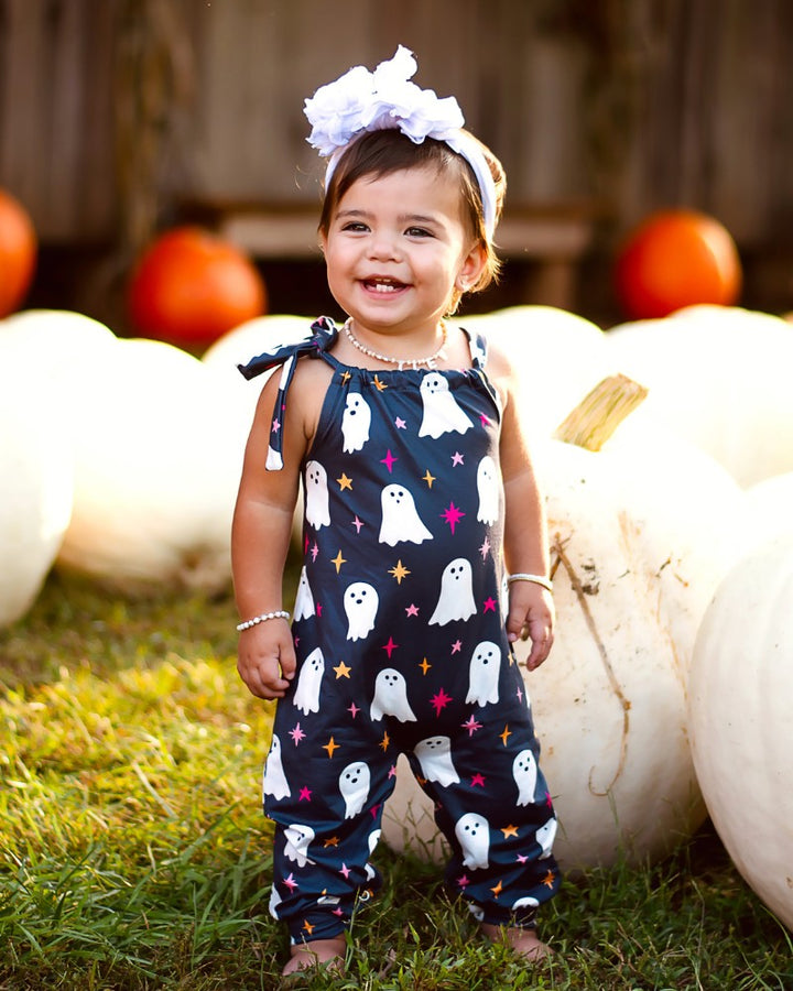 Sea Dragon Dreams toddler jumpsuit in black with white ghost and pink sparkle print, featuring adjustable tie straps.