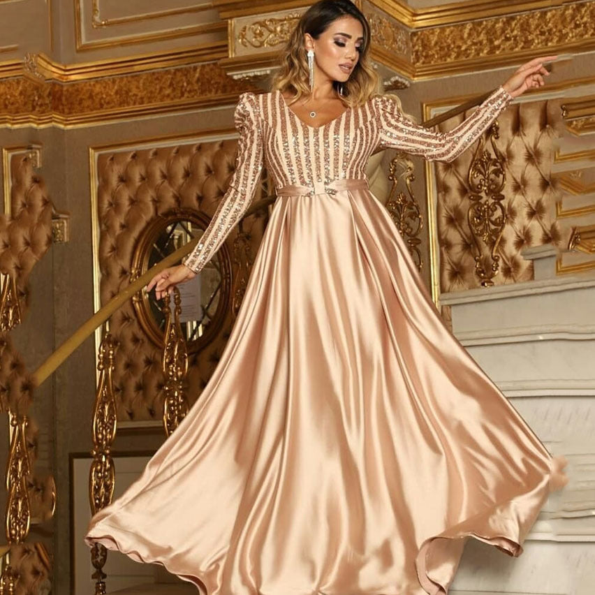 Sea Dragon Dreams gold evening maxi dress with long sequin sleeves, V-neckline, and a flowing satin swing skirt