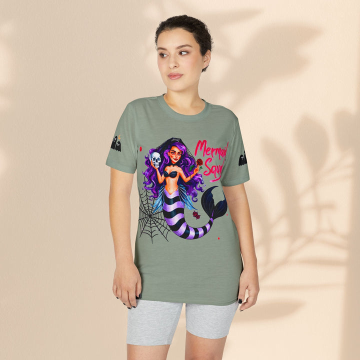 Model wearing a Sea Dragon Dreams sage green graphic t-shirt featuring a gothic mermaid illustration with purple hair.