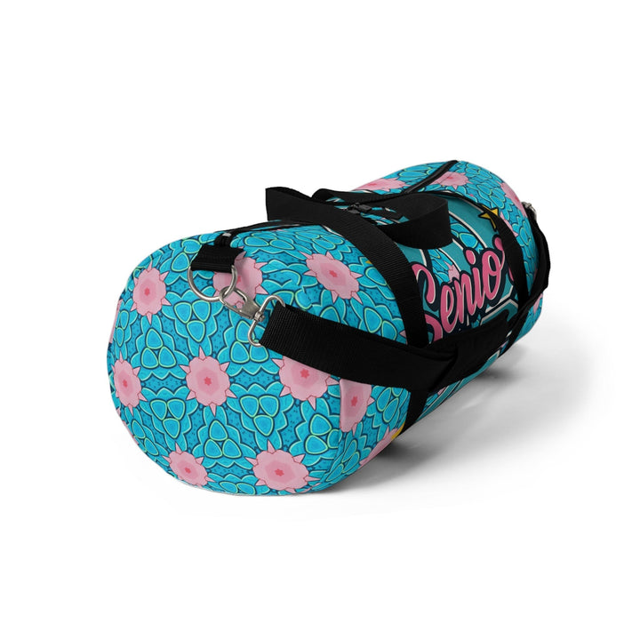 Sea Dragon Dreams 2026 Graduate duffel bag in blue with pink floral patterns, featuring black straps and zipper.