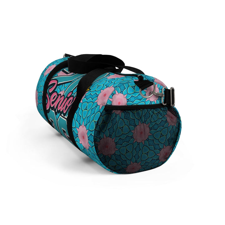 Sea Dragon Dreams 2026 Graduate duffel bag in blue with pink floral patterns, mesh side pocket, and black straps.