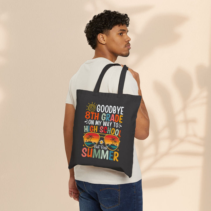 Sea Dragon Dreams black cotton canvas tote bag with 8th grade graduation print worn over the shoulder by a young man.
