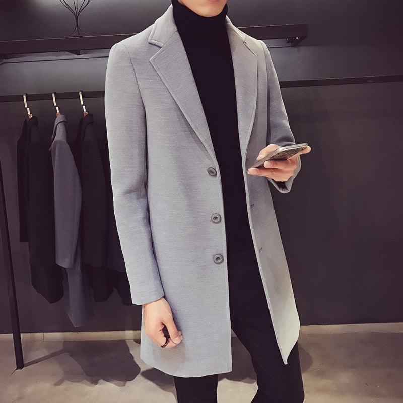 Sea Dragon Dreams men's grey cotton trench coat with a turn-down collar, worn over a black turtleneck sweater.