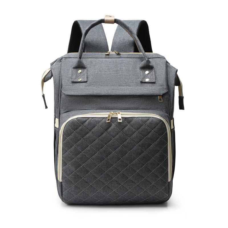 Sea Dragon Dreams grey diaper backpack with a quilted front pocket, gold zippers, and top carry handles.