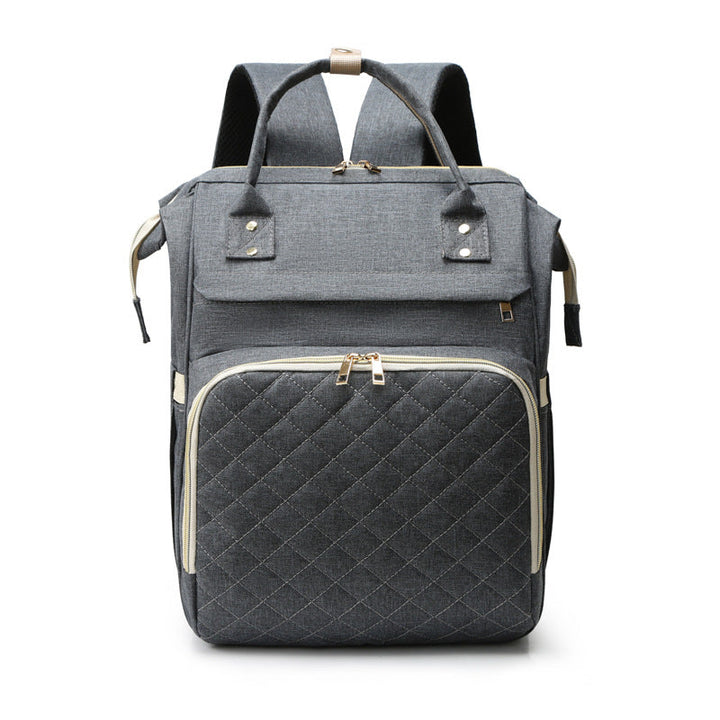 Sea Dragon Dreams grey diaper backpack with a quilted front pocket, gold zippers, and top carry handles.