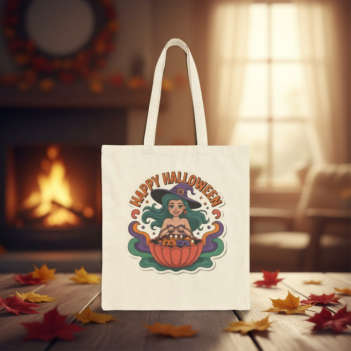 Sea Dragon Dreams cotton canvas tote bag featuring a cute witch illustration and Happy Halloween text on a table.