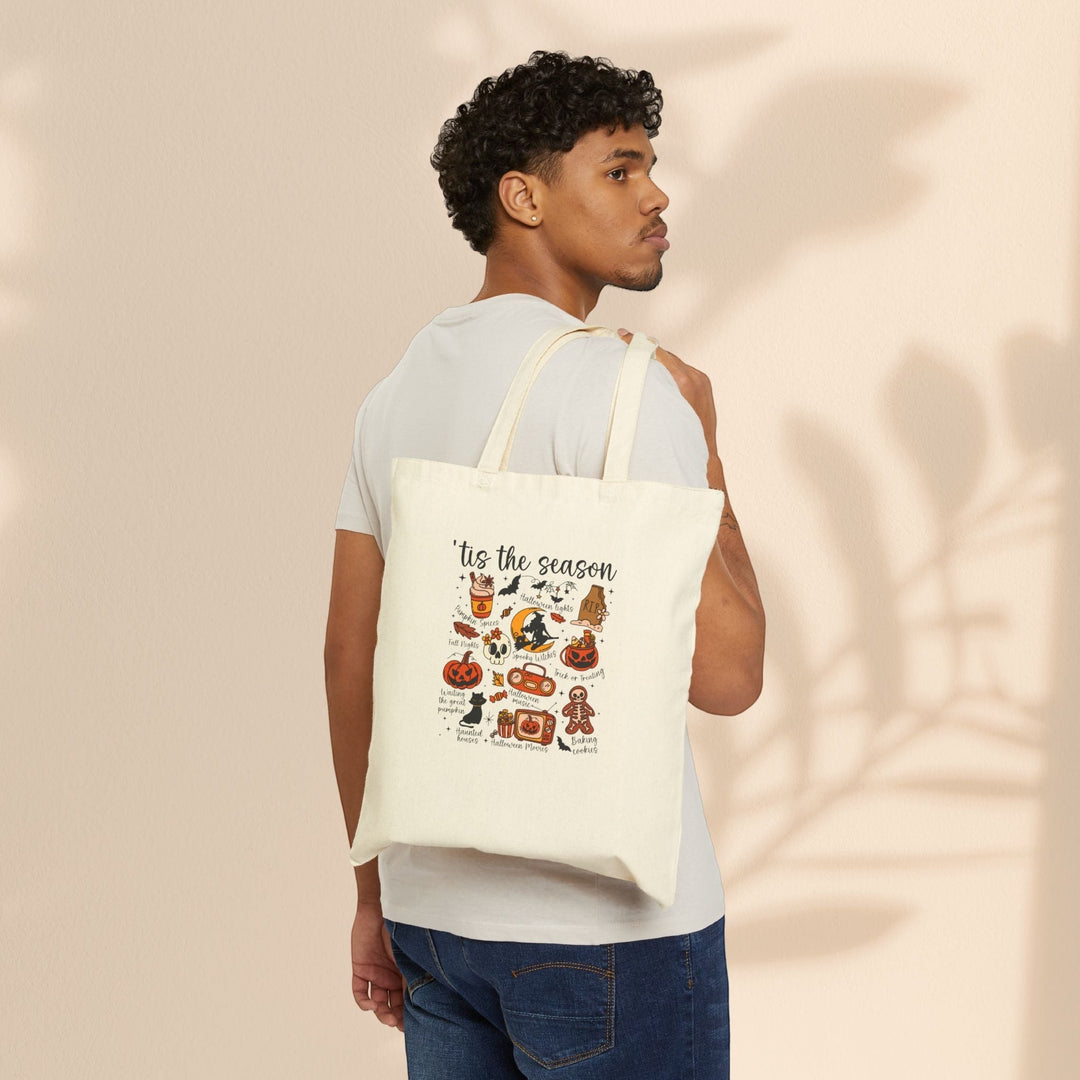 Sea Dragon Dreams natural cotton canvas tote bag with festive Halloween graphics worn over the shoulder by a man.