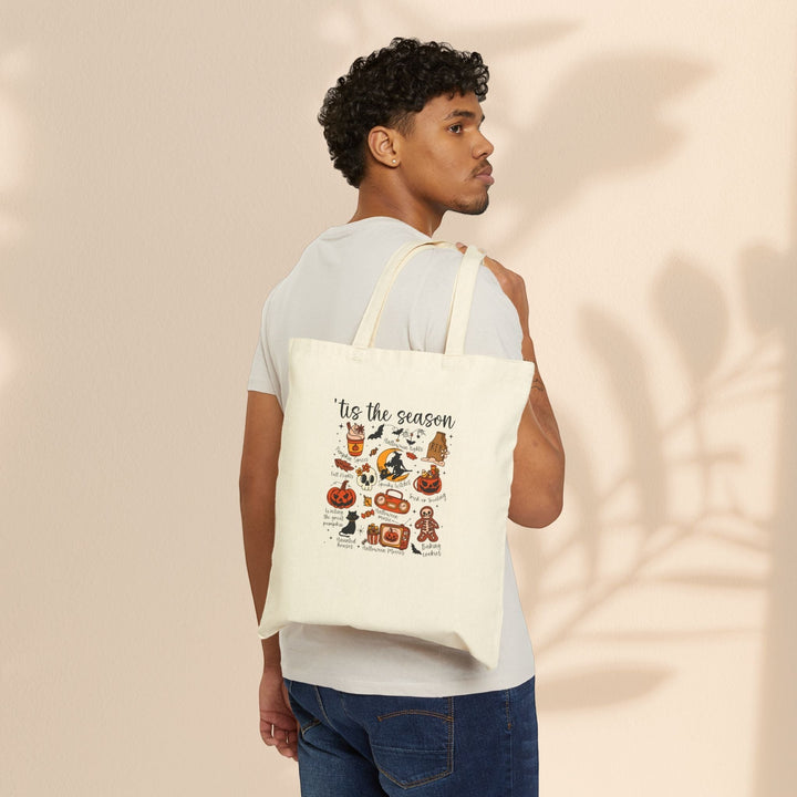 Sea Dragon Dreams natural cotton canvas tote bag with festive Halloween graphics worn over the shoulder by a man.