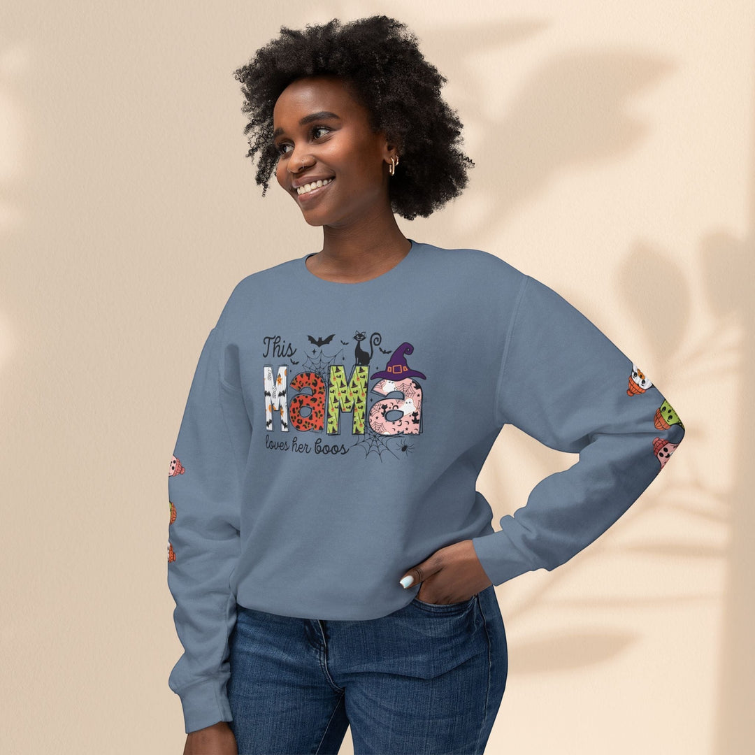 Sea Dragon Dreams blue crewneck sweatshirt with This Mama Loves Her Boos Halloween print worn by a smiling woman.