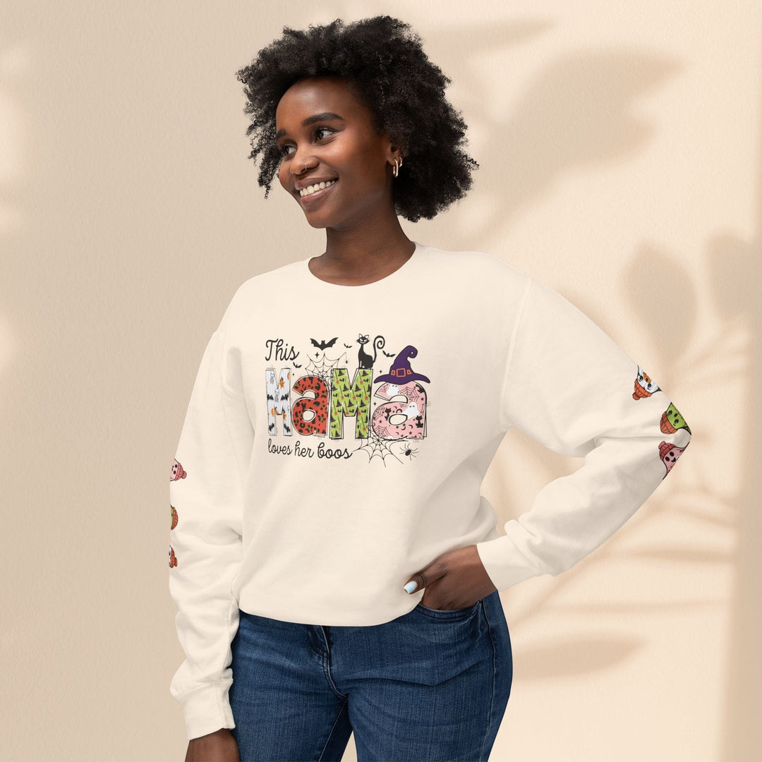 Sea Dragon Dreams cream crewneck sweatshirt with This Mama Loves Her Boos Halloween print worn by a smiling woman.