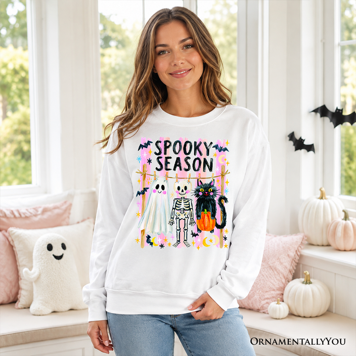 Sea Dragon Dreams white sweatshirt featuring a colorful Spooky Season ghost, skeleton, and black cat graphic design.
