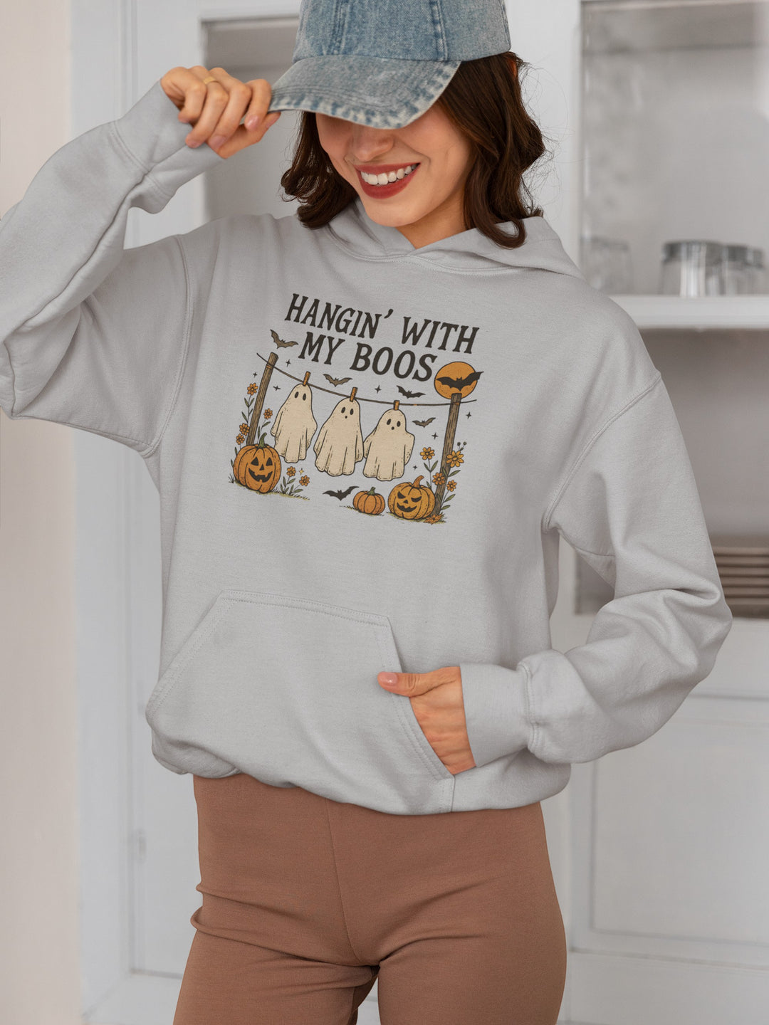 Sea Dragon Dreams light grey Halloween hoodie with a Hanging With My Boos ghost and pumpkin graphic on a woman