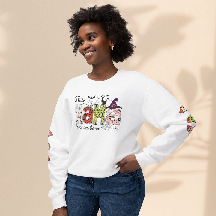 Sea Dragon Dreams white crewneck sweatshirt with This Mama Loves Her Boos Halloween graphic worn by a smiling woman.