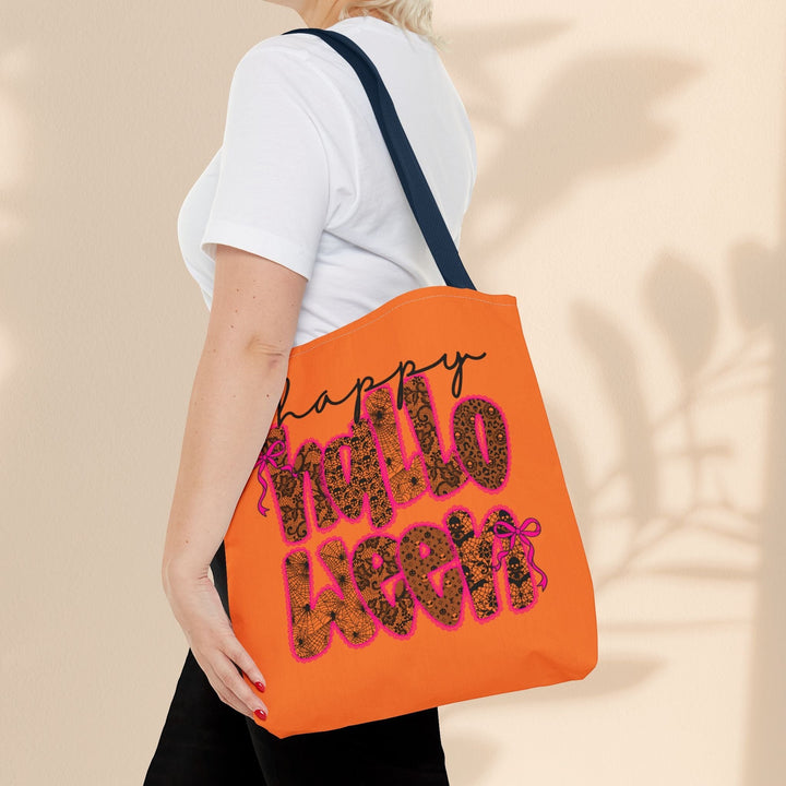 Sea Dragon Dreams Happy Halloween tote bag in orange with black text and spiderweb pattern, worn over the shoulder.
