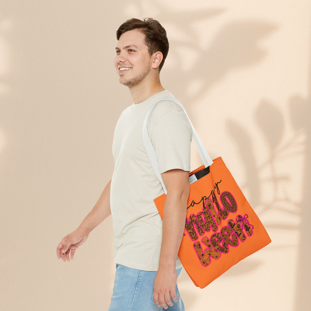 Sea Dragon Dreams Happy Halloween tote bag with orange fabric and festive text, carried by a man in a light t-shirt.