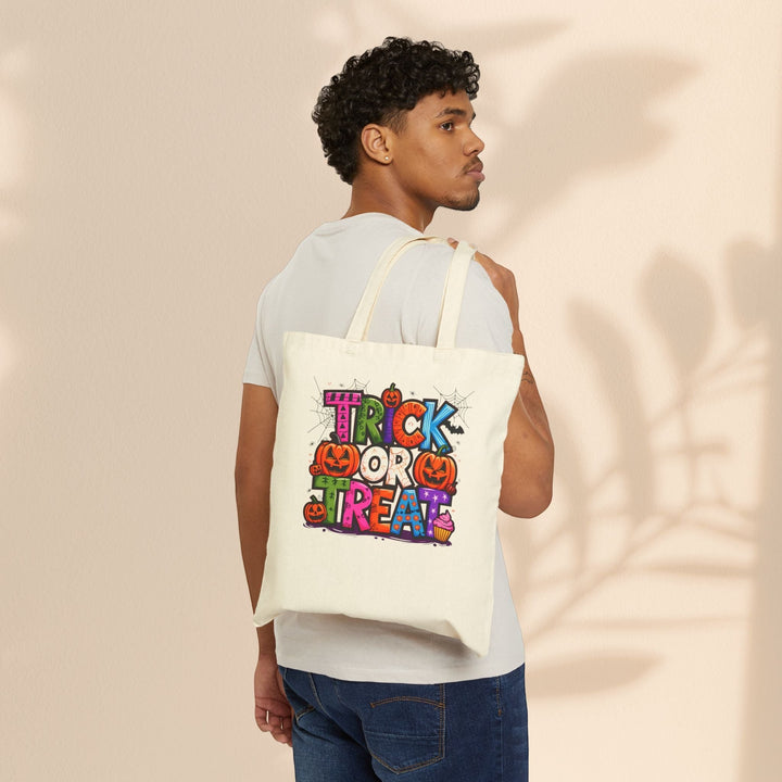 Sea Dragon Dreams natural cotton canvas tote bag with colorful Halloween Trick or Treat print worn by a man.