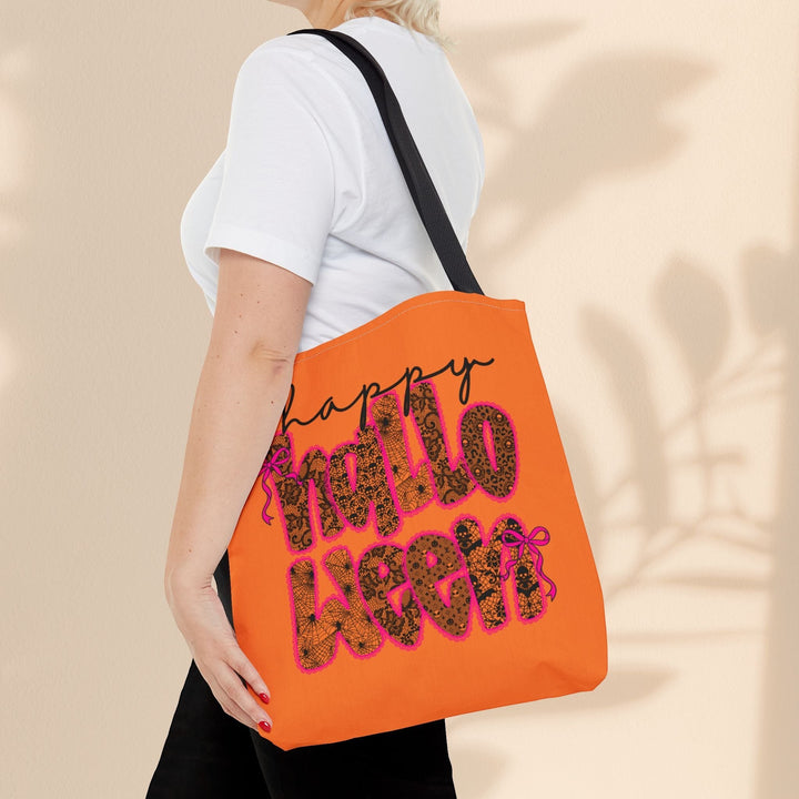 Sea Dragon Dreams Happy Halloween tote bag with orange fabric and black spiderweb text carried over a shoulder.