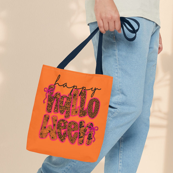 Sea Dragon Dreams orange polyester tote bag with Happy Halloween text, leopard print, and pink bows held by a person.