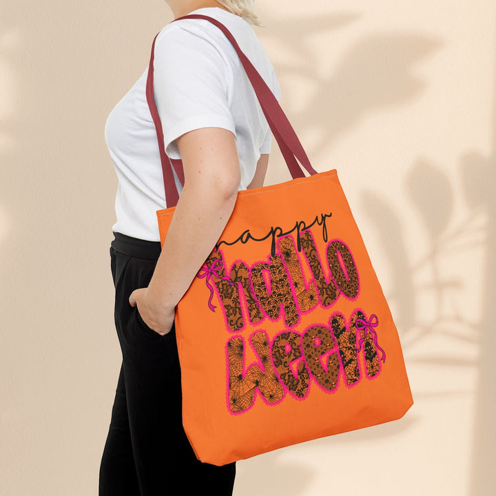 Sea Dragon Dreams orange Happy Halloween tote bag with leopard print lettering worn over the shoulder by a woman.