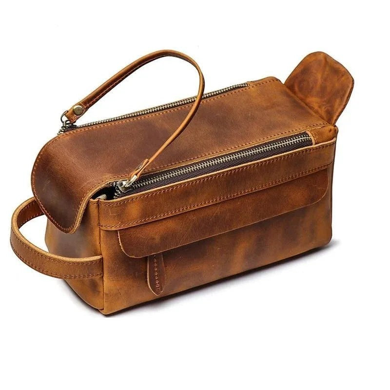 Sea Dragon Dreams handmade brown leather dopp kit with a zippered top, side handle, and front storage pocket.
