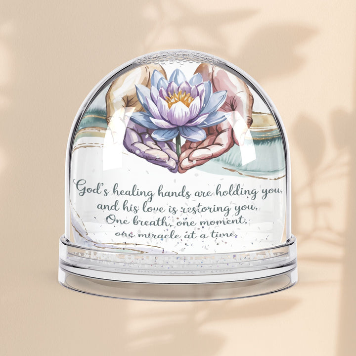 Sea Dragon Dreams inspirational snow globe featuring a lotus flower held in hands with a healing faith message.