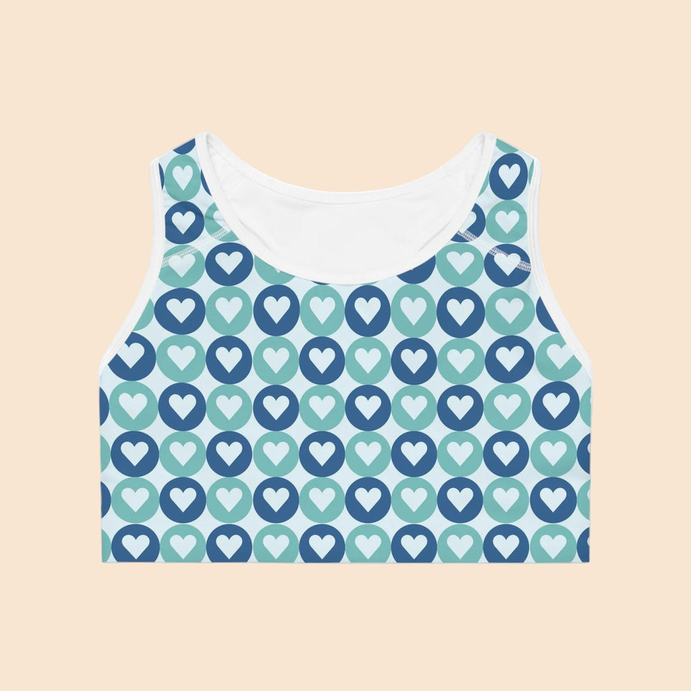 Sea Dragon Dreams sports bra featuring a blue and teal heart pattern on moisture-wicking athletic fabric.
