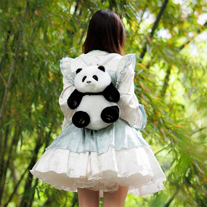 Sea Dragon Dreams Hehua panda plush mini backpack worn by a person in a light blue dress in a bamboo forest.