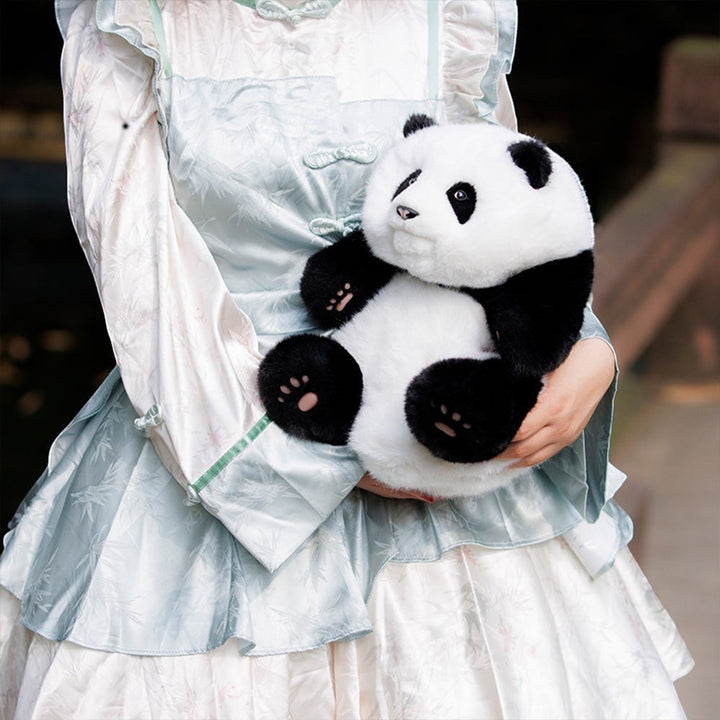 Sea Dragon Dreams Hehua panda plush backpack held by a person wearing a light blue traditional-style dress.