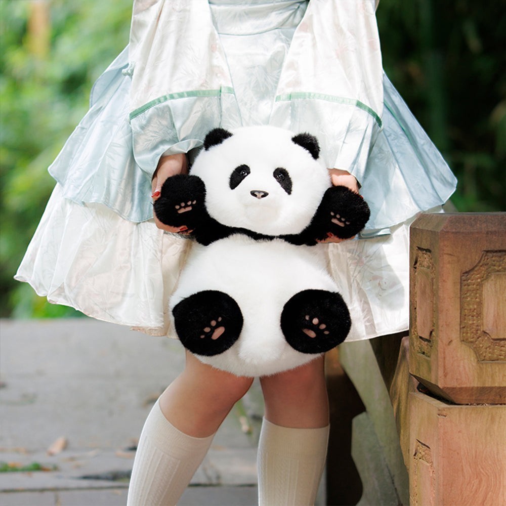 Sea Dragon Dreams Hehua panda plush mini backpack held by a person wearing a light blue dress and white socks.