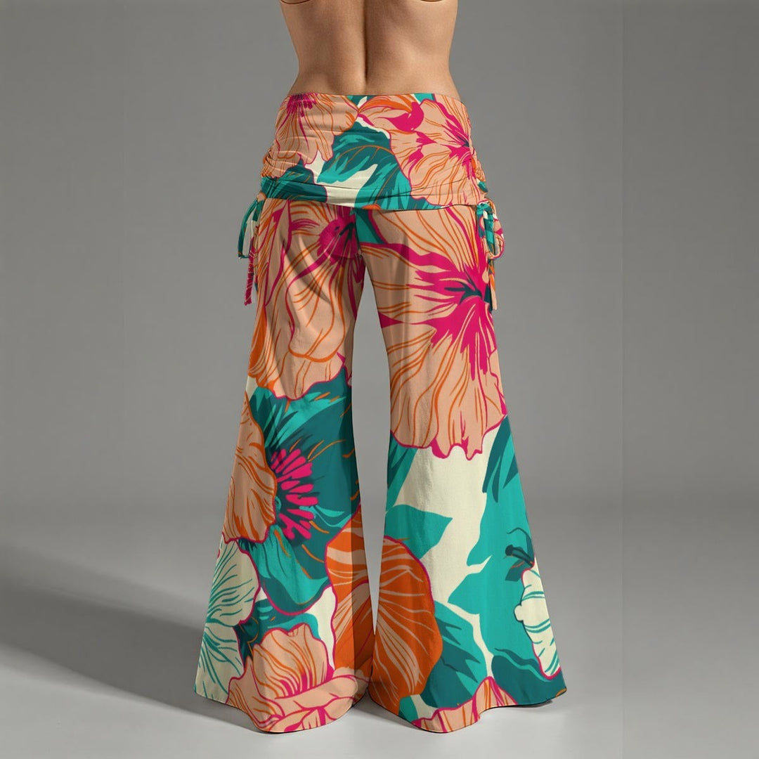 Sea Dragon Dreams high-waist wide-leg pants with a vibrant tropical hibiscus floral print and adjustable side pleats.