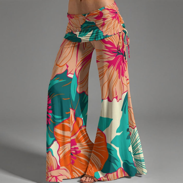 Sea Dragon Dreams high-waist wide-leg pants with a vibrant tropical hibiscus floral print and adjustable side pleats.