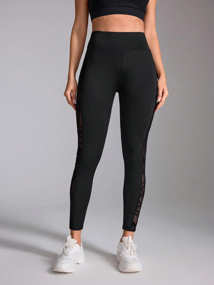 Sea Dragon Dreams high-waist black workout leggings with side contrast mesh stitching and a supportive fit.