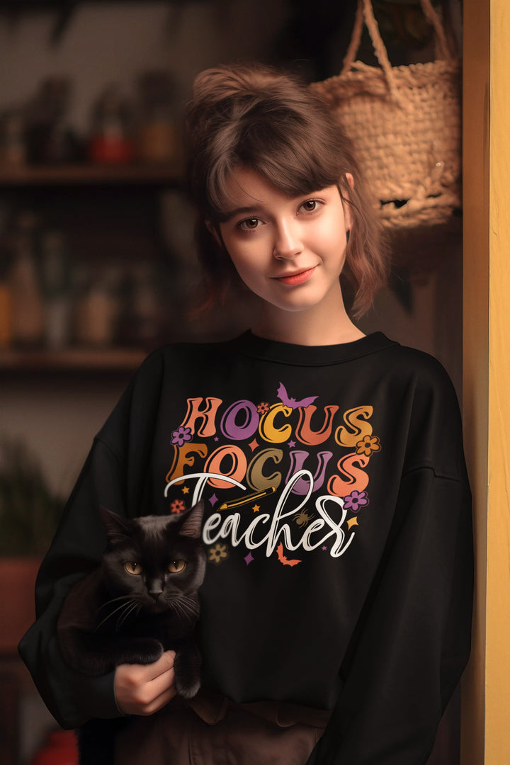 Sea Dragon Dreams black crewneck sweatshirt with Hocus Focus Teacher graphic, worn by a woman holding a black cat.