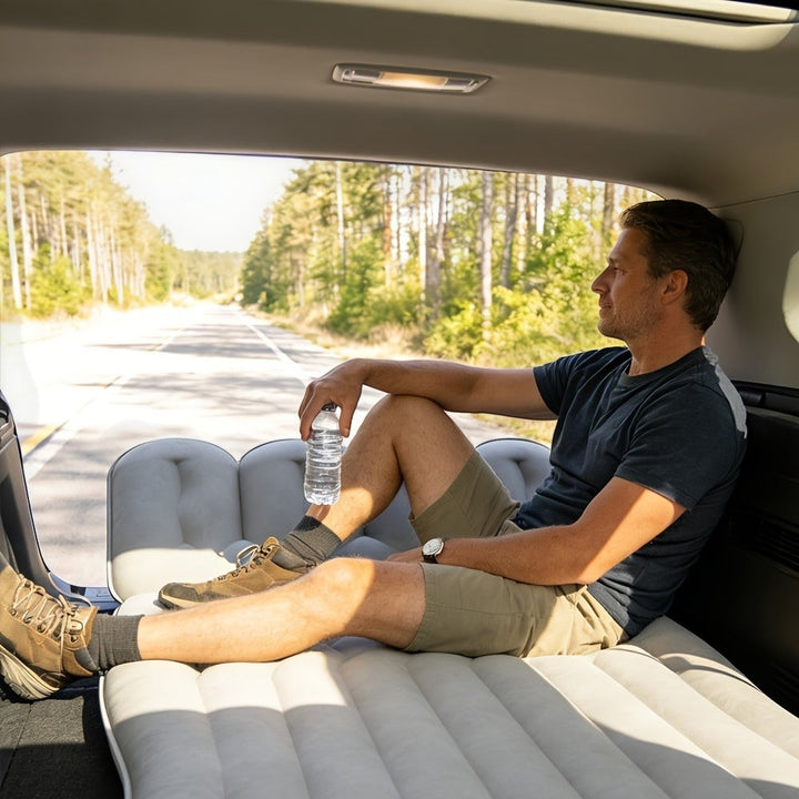 Sea Dragon Dreams inflatable car mattress in grey PVC with soft flocking, used by a man resting in an SUV backseat.