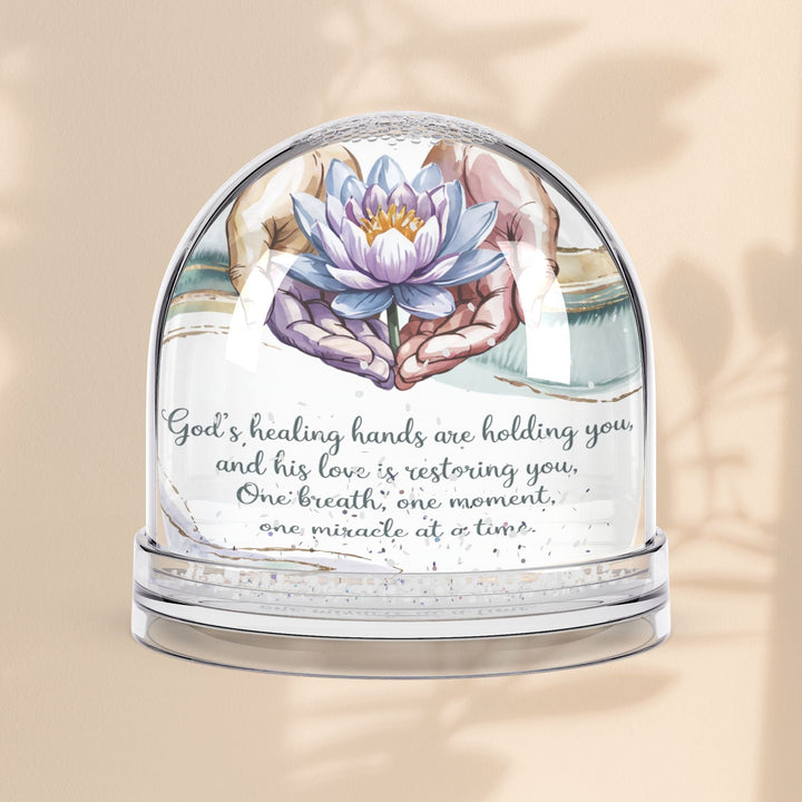 Sea Dragon Dreams inspirational snow globe featuring a lotus flower and the message God's Healing Hands Are Holding You