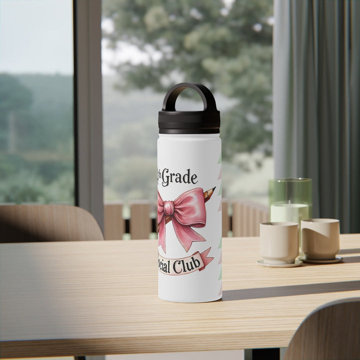 Sea Dragon Dreams insulated water bottle with 4th Grade Social Club bow design on a wooden table in a bright room.