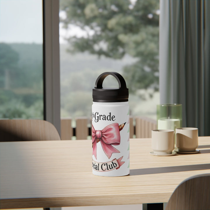 Sea Dragon Dreams 4th Grade Social Club insulated water bottle with a pink bow and pencil design on a wooden table.