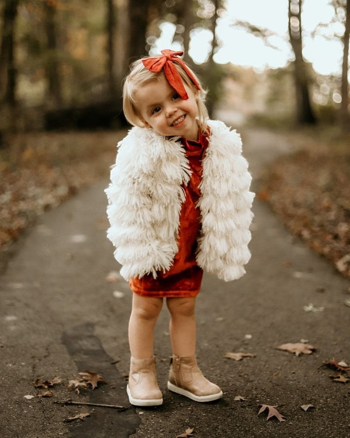 Sea Dragon Dreams ivory faux shag layered jacket worn by a young girl in a park setting