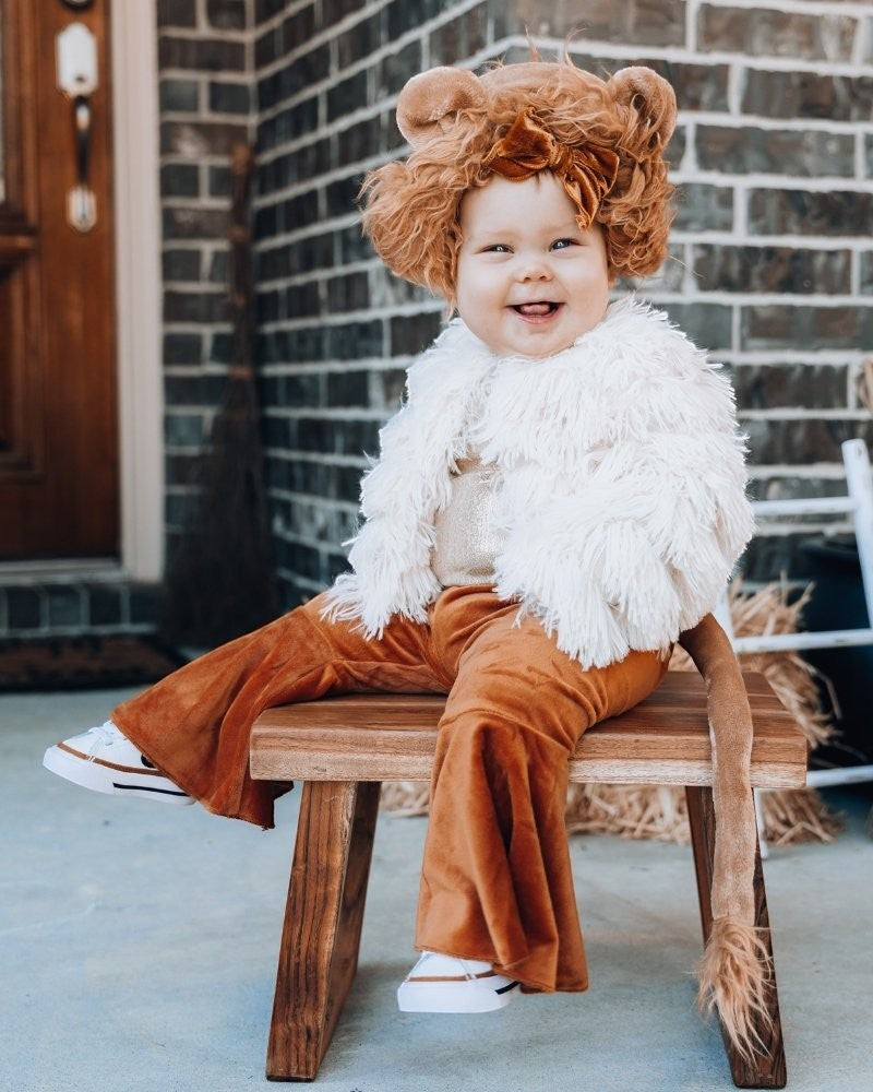 Sea Dragon Dreams ivory faux shag layered jacket worn by a smiling toddler in a lion costume on a wooden stool