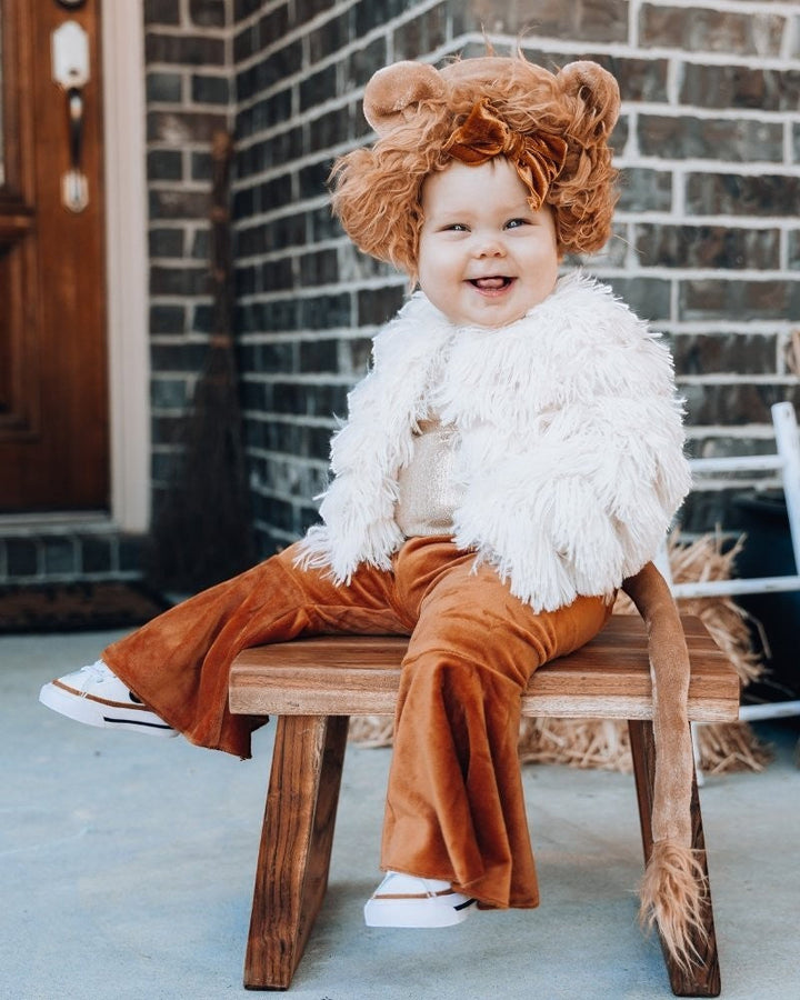 Sea Dragon Dreams ivory faux shag layered jacket worn by a smiling toddler in a lion costume on a wooden stool