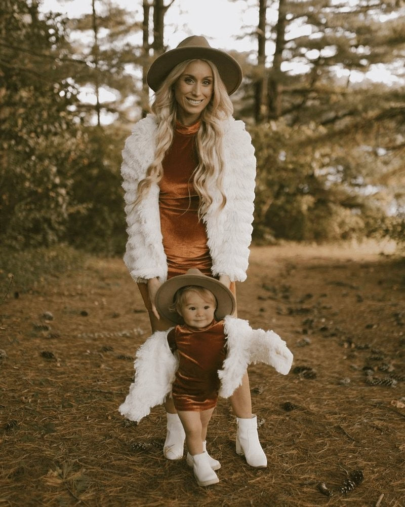 Sea Dragon Dreams ivory faux shag layered jackets worn by a mother and child in a forest setting