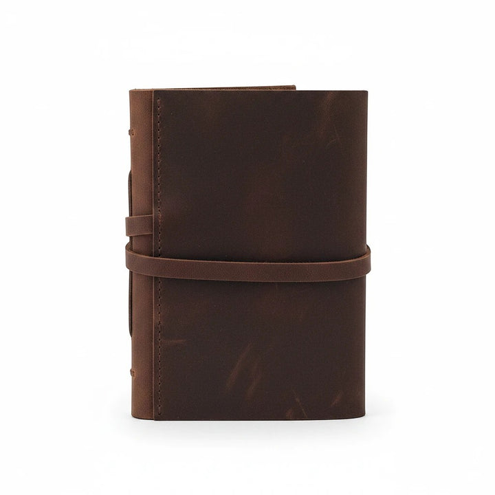 Sea Dragon Dreams Kodiak leather travel journal with a rustic brown wrap-around strap closure on a white background.
