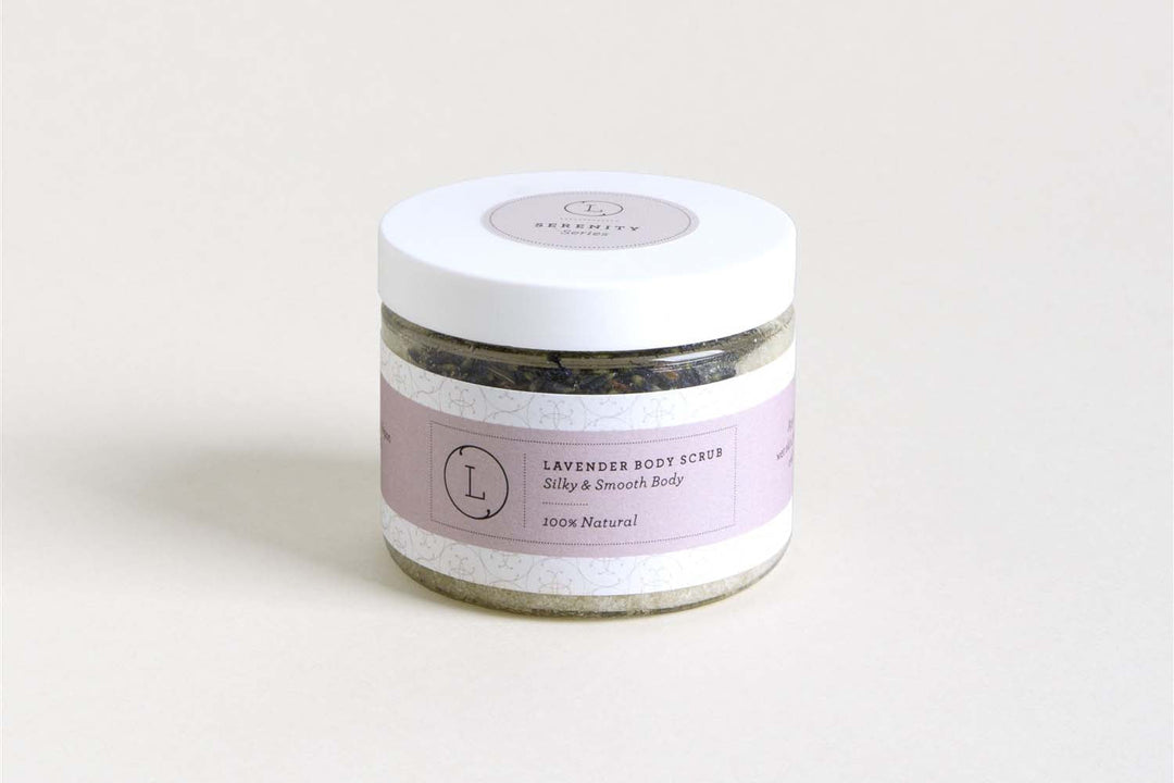 Sea Dragon Dreams lavender body scrub in a clear jar with a white lid and a soft purple label on a neutral background.