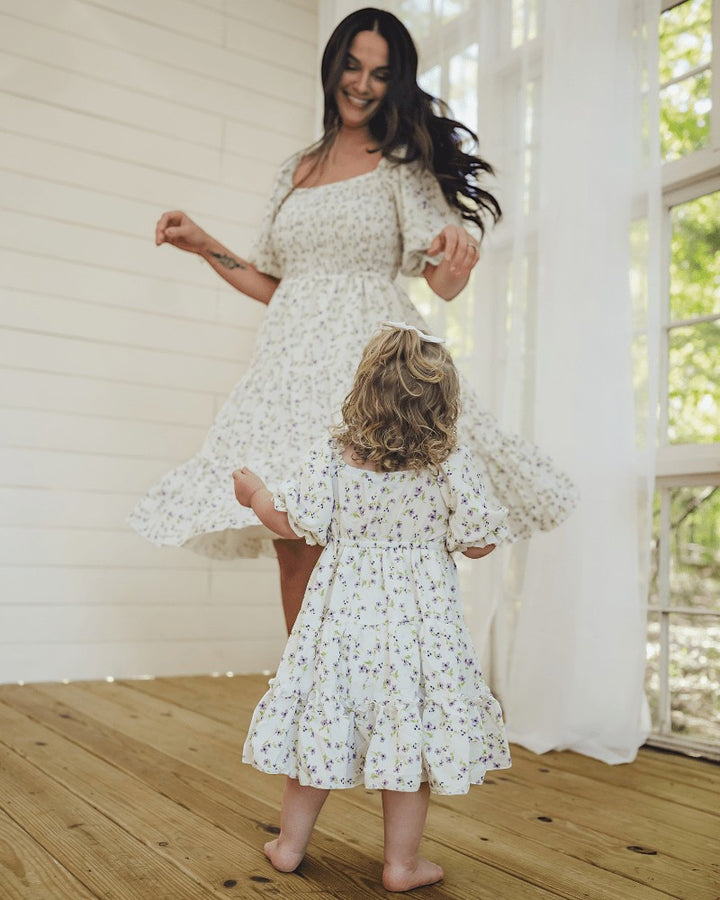 Sea Dragon Dreams mother and daughter wearing matching lavender floral print Katherine dresses while dancing indoors