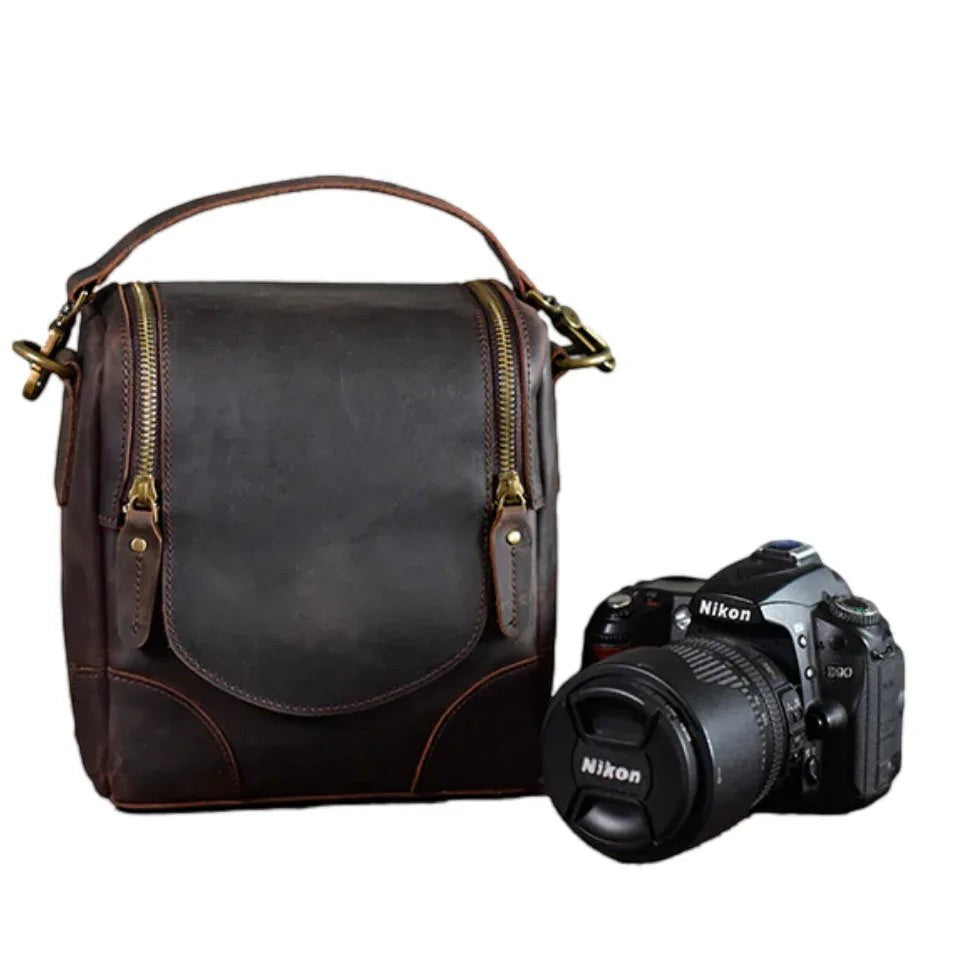Sea Dragon Dreams The Calista handcrafted dark brown full-grain leather camera bag with a DSLR camera beside it.