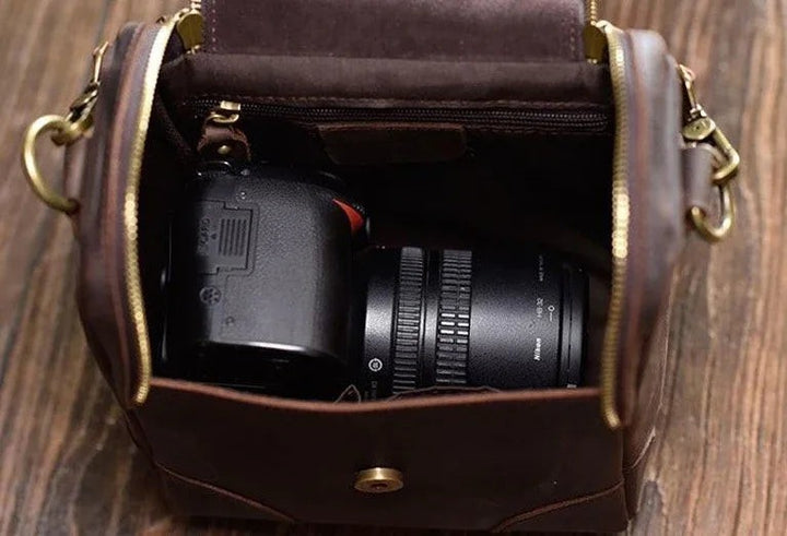Sea Dragon Dreams Calista brown full-grain leather camera bag with a DSLR camera inside and brass hardware.